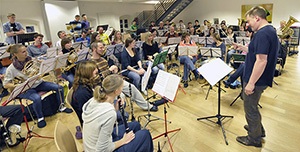 Eine Musikgruppe Sitz im Halbkreis und probt im Tagungsraum der Jugendherberge Bad Begraben auf verschiedenen Blasinstrument. 